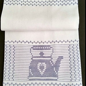 Puede incluir: Toalla de cocina blanca con un diseño bordado azul de una tetera con un corazón en la parte delantera. La toalla tiene un borde azul.