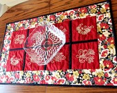 Embroidered patchwork table runner, gold coloured flowers and leaves in satin stitch embroidery on red