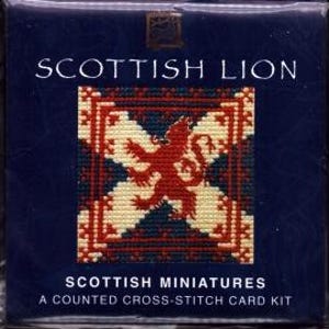 May include: A white ceramic mug with a black handle and the text "But First, Coffee" in a bold, black font. The mug is set against a blurred background, suggesting a cozy setting.