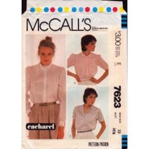 May include: A McCall's 7623 sewing pattern envelope featuring three variations of a blouse. The cover displays photographs of blouses with different collar styles, sleeve lengths, and button-front closures, along with the Cacharel brand logo.