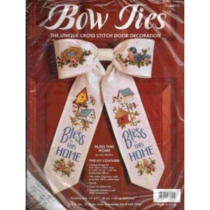 May include: A cross stitch kit for a door decoration. The kit includes two white fabric bow ties with the words "Bless This Home" embroidered on them. The bow ties are decorated with a birdhouse and floral designs.