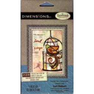 May include: A colorful, stained glass-style birdcage with a bird inside. The cage is surrounded by a white frame and the text "When the soul sings" is printed above the cage. The image is a rubber stamp designed by Lori Siebert.