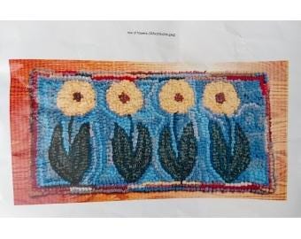 May include: A rectangular rug with a blue background and four yellow flowers with brown centers. The flowers have green leaves and are set against a blue background. The rug has a red border and a wooden frame.
