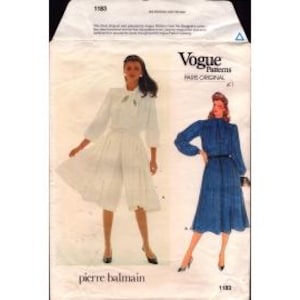 May include: Vogue Patterns sewing pattern featuring designs by Pierre Balmain. The pattern includes instructions for a white blouse and culottes, and a blue dress. The pattern envelope is white with images of the finished garments.