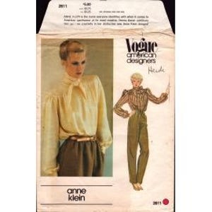 May include: Vintage Vogue American Designers sewing pattern featuring an Anne Klein design. The pattern includes instructions for a blouse and pants. The package shows a photo of a woman wearing the blouse and pants. The pattern number is 2611.
