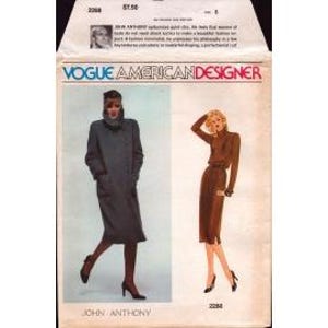 May include: Vintage Vogue American Designer sewing pattern featuring two women's fashion designs by John Anthony. The pattern includes a long, dark gray coat and a brown dress with a matching belt. The pattern number is 2268.