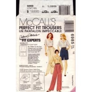 May include: A McCall's sewing pattern envelope for Perfect Fit Trousers, number 6985, size 16. The white paper envelope features illustrations of three different trouser styles in beige, navy blue, and red, along with text and barcodes.