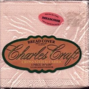 May include: A square of Charles Craft cross stitch fabric, 18" x 18", in a soft, light pink color. The fabric is packaged in clear plastic and has a label that reads "BREAD COVER" and "Charles Craft". The label also indicates the fabric is EZCARE Dacron Polyester.