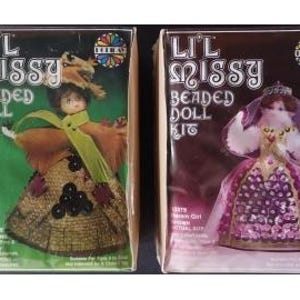 May include: Two vintage "Lil Missy Beaded Doll Kit" boxes. One box features a doll in a brown dress with a green sash and a hat. The other box shows a doll in a pink dress with a crown. Each box has text and a colorful design.