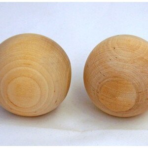 May include: Two smooth, wooden spheres, each with a light brown color and a slightly textured surface.