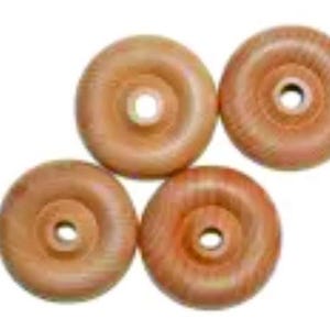 May include: Four wooden wheels with a light brown color and a slightly reddish hue. The wheels have a center hole and a raised rim around the edge.