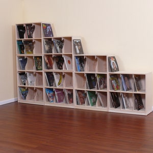May include: A set of five wooden record shelves with a staggered design. The shelves are filled with vinyl records. The shelves are made of light wood and have a natural finish.