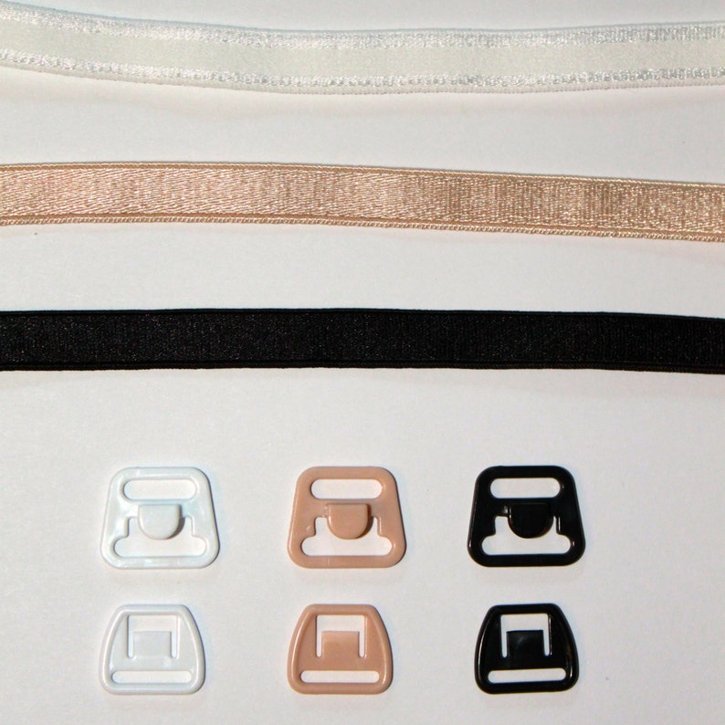 May include: Three sets of bra strap adjusters in white, beige, and black. Each set includes a hook and eye closure and a slider.