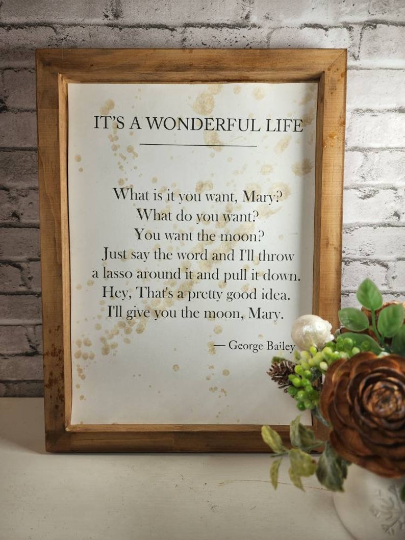 May include: A framed print with a quote from the movie "It's a Wonderful Life." The quote reads: "What is it you want, Mary? What do you want? You want the moon? Just say the word and I'll throw a lasso around it and pull it down. Hey, That's a pretty good idea. I'll give you the moon, Mary." - George Bailey