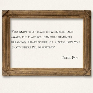 May include: A rectangular wooden frame containing a white print with black text that reads: "You know that place between sleep and awake, the place you can still remember dreaming? That's where I'll always love you. That's where I'll be waiting." -Peter Pan.