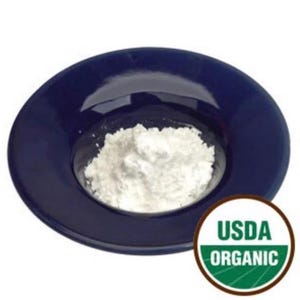 May include: A deep blue ceramic bowl filled with a mound of white powder. The bowl is round with a wide rim. A USDA ORGANIC seal is visible in the lower right corner.
