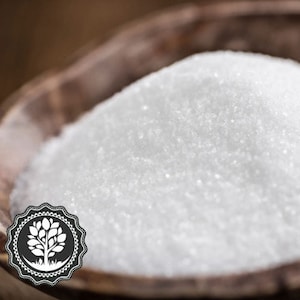 May include: A close-up of a white granulated sugar in a wooden bowl. The sugar is fine and smooth, with a slight sheen.