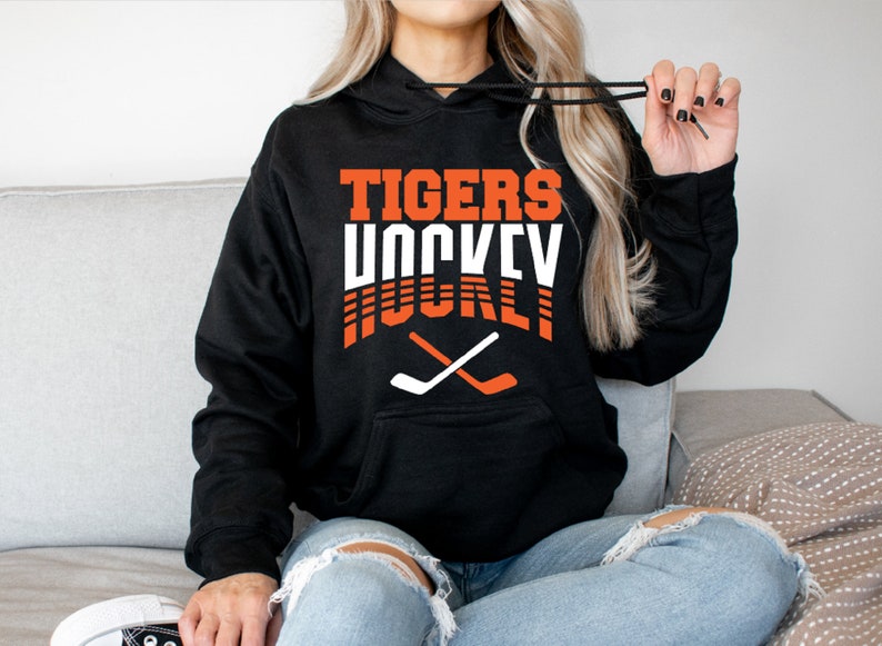 May include: Black hoodie with the text "TIGERS HOCKEY" in orange and white with two crossed hockey sticks in white and orange.
