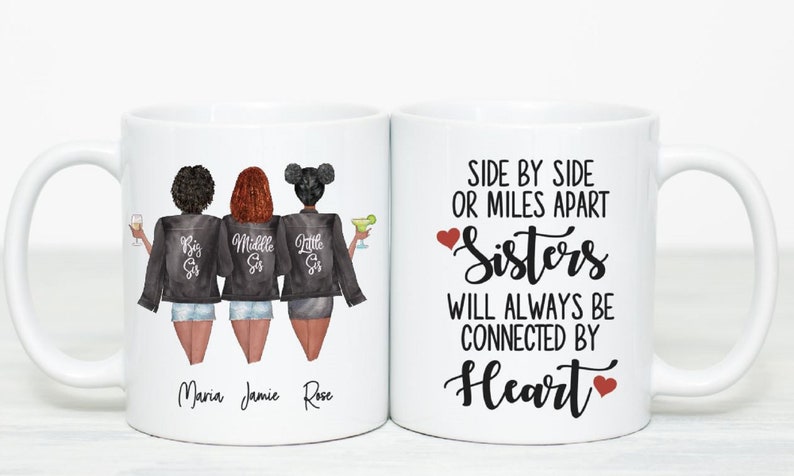 Puede incluir: Taza de cer&aacute;mica blanca con una ilustraci&oacute;n en blanco y negro de tres hermanas con el texto "Big Sis", "Middle Sis" y "Little Sis" en sus chaquetas. La taza tambi&eacute;n tiene el texto "Side by Side or Miles Apart Sisters Will Always Be Connected By Heart" con un coraz&oacute;n rojo a cada lado del texto.