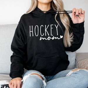 May include: Black hoodie with a white graphic that says "HOCKEY mom" with a small heart.