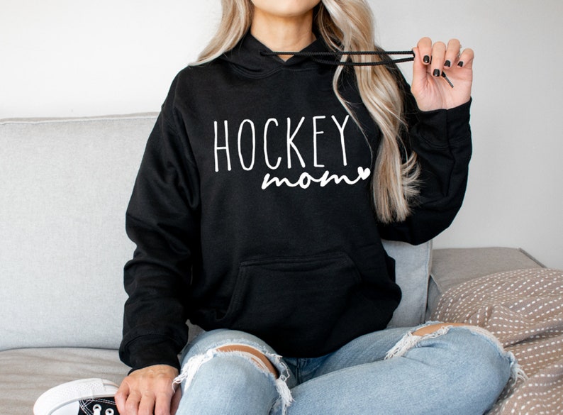 May include: Black hoodie with a white graphic that says "HOCKEY mom" with a small heart.