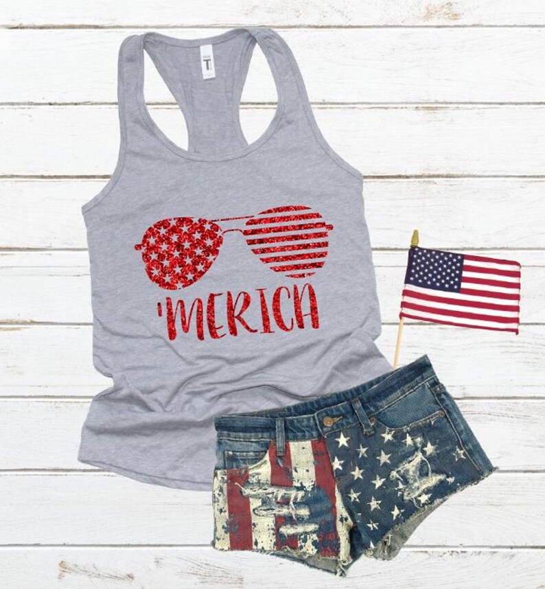 May include: A grey tank top with a red glitter design of sunglasses with an American flag pattern. The text 'MERICA' is printed below the sunglasses.