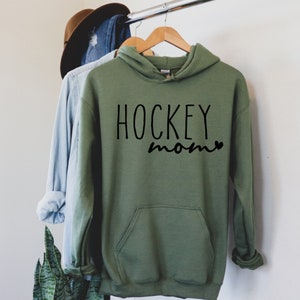 May include: A green hooded sweatshirt with the text "HOCKEY mom" in black lettering.