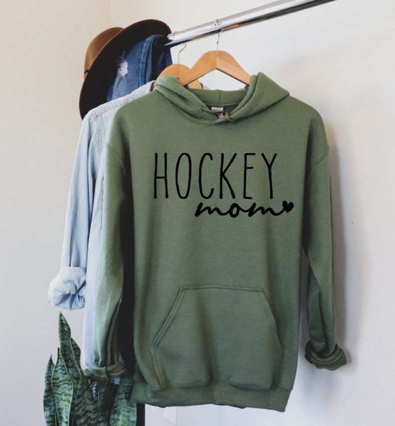 May include: A green hooded sweatshirt with the text "HOCKEY mom" in black lettering.