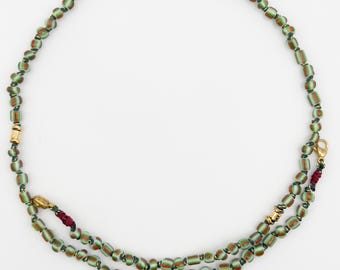 Halsketten zur Herstellung afrikanischer Perlen in den Farben Grün, Rot und Weiß.