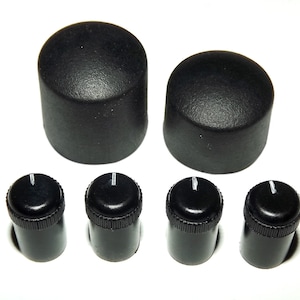 May include: Set of five black plastic knobs with a white line on each. Two larger knobs are round and two smaller knobs are cylindrical. One smaller knob is missing a white line.