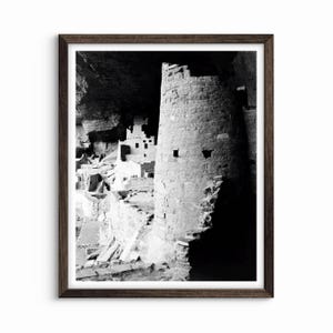 Puede incluir: Fotograf&iacute;a en blanco y negro de una vivienda en un acantilado en una cueva. La vivienda est&aacute; hecha de piedra y tiene una torre en primer plano. La torre est&aacute; parcialmente a la sombra, y el resto de la vivienda est&aacute; a la luz.