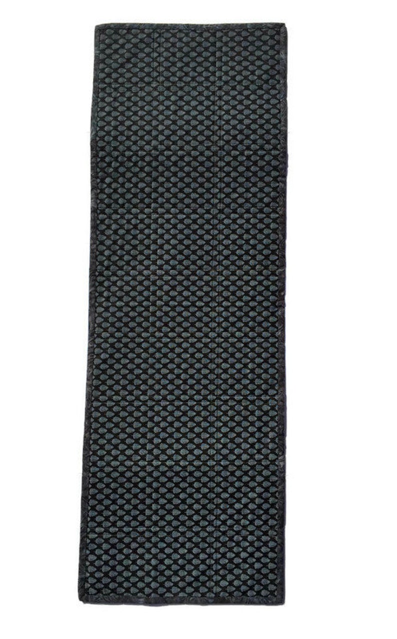 May include: Black and gray textured rectangular rug with a repeating pattern of small circles.