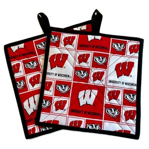 May include: Two red and white pot holders with a black border. The pot holders feature a repeated pattern of the University of Wisconsin logo, a badger mascot, and the words "University of Wisconsin".