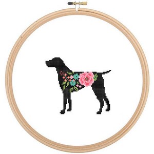 Może przedstawiać: Czarna sylwetka psa z kwiatowym wzorem na grzbiecie. Pies stoi na białym tle i jest osadzony w drewnianej obręczy do haftu.