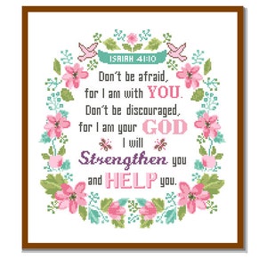 May include: Cross-stitch pattern featuring a floral wreath with pink flowers and green leaves. The center of the wreath contains a quote from Isaiah 41:10: "Don't be afraid, for I am with YOU. Don't be discouraged, for I am your GOD. I will Strengthen you and HELP you."