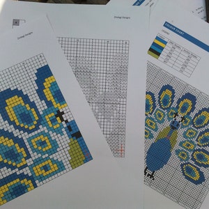 May include: A color chart for a cross stitch pattern of a peacock with blue, yellow, and green colors. The chart includes a legend with color codes and DMC thread numbers.
