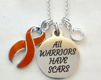 May include: Silver necklace with an orange ribbon charm and a round pendant that says "All Warriors Have Scars".