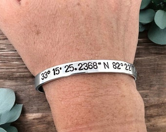 May include: A silver bracelet with the coordinates "33° 15' 25.2368" N 82° 22' 22.7024" engraved on it.
