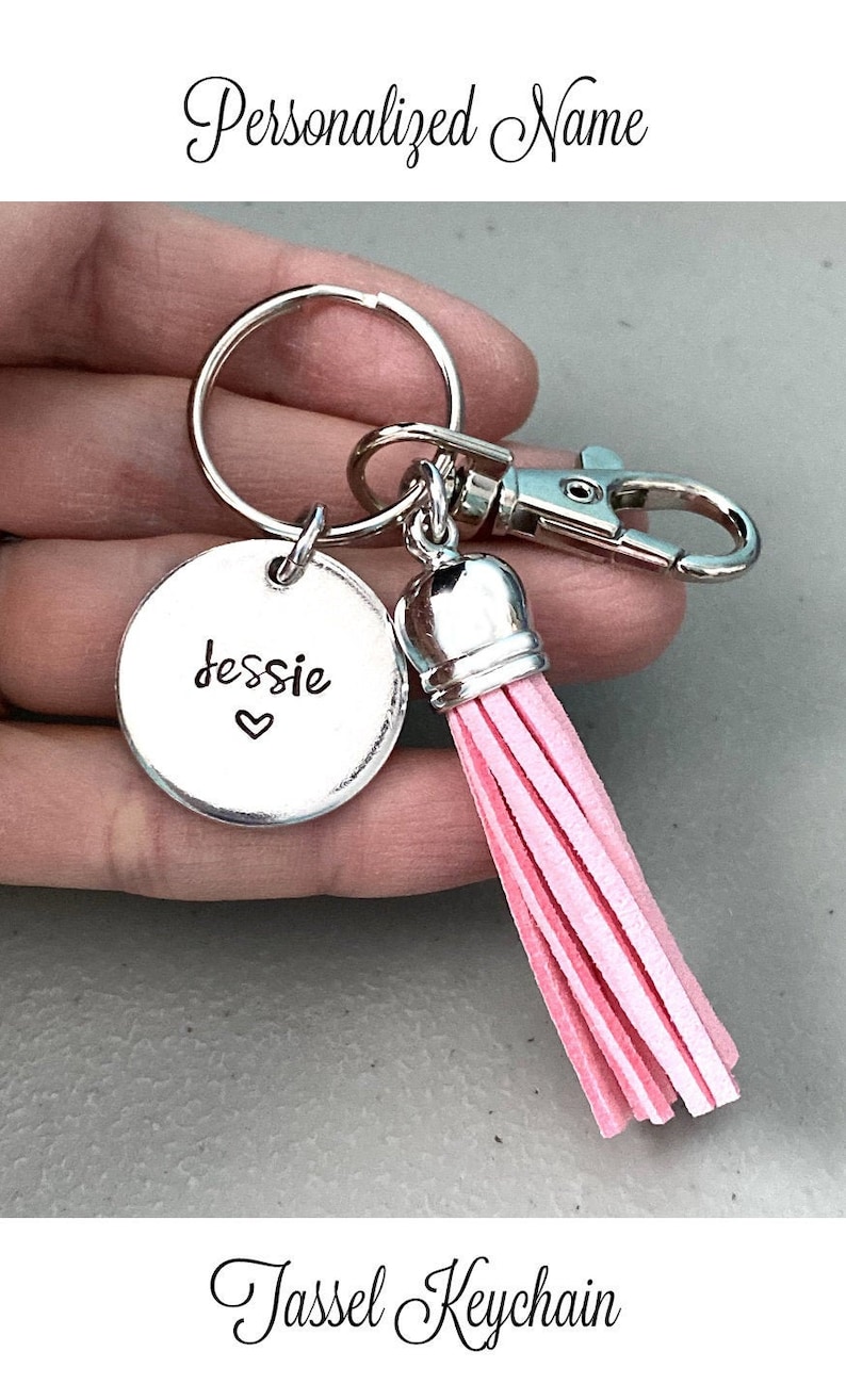 May include: A silver keychain with a round charm that says "Jessie" with a heart. The keychain has a pink tassel.