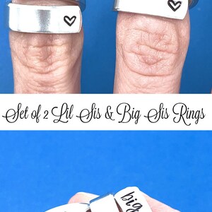 May include: Set of two silver rings with the words "lil sis" and "big sis" engraved on them. Each ring has a small heart engraved on the side.