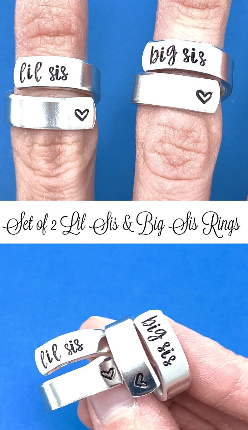 May include: Set of two silver rings with the words "lil sis" and "big sis" engraved on them. Each ring has a small heart engraved on the side.