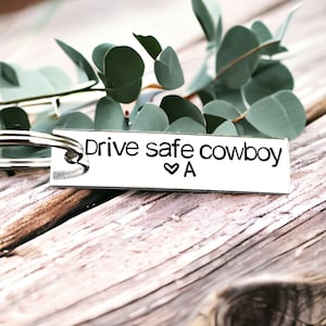 May include: Silver keychain with the text "Drive safe cowboy ♥ A" engraved on it.