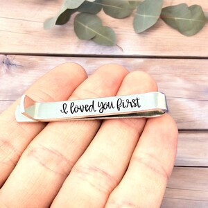 May include: Silver tie clip with the inscription "I loved you first" engraved on it.