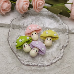 May include: Four colourful mushroom charms with white dots and happy faces. The charms are made of polymer clay and have a silver loop for hanging.