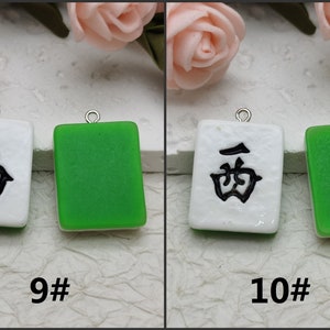 Puede incluir: Dos fichas de mahjong de cer&aacute;mica blanca y verde con caracteres chinos negros. La ficha de la izquierda tiene el car&aacute;cter "sur" y la ficha de la derecha tiene el car&aacute;cter "oeste". Las fichas est&aacute;n numeradas 9 y 10.
