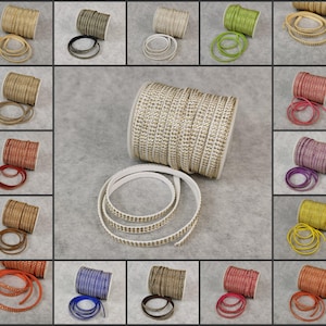 Op de afbeelding: Een assortiment van leren koorden in verschillende kleuren met strass. Het koord is op spoelen gewikkeld en is verkrijgbaar in kleuren zoals zwart, wit, rood, blauw, groen en geel.