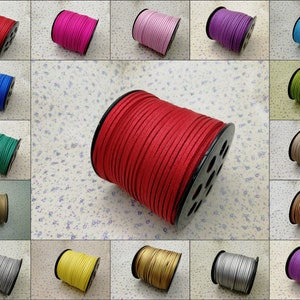 Op de afbeelding: Assortiment van 12 spoelen met kunstleerkoord in verschillende kleuren, waaronder rood, blauw, groen, bruin, beige, goud, zilver, paars, roze en turquoise. Elke spoel is gewikkeld met een koord in een andere kleur.
