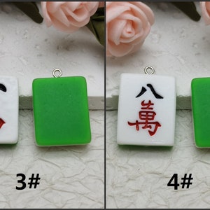 Puede incluir: Dos juegos de azulejos de cer&aacute;mica blanca y verde con caracteres chinos y una l&iacute;nea negra. Los azulejos cuelgan de lazos plateados. Los azulejos est&aacute;n etiquetados como 3# y 4#.