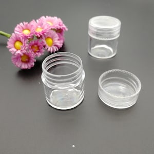 Op de afbeelding: Drie transparante plastic containers met deksels. De containers zijn van verschillende grootte en hebben een gladde, glanzende afwerking.