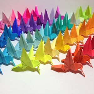 May include: A rainbow of origami hummingbirds, each folded from a different colored paper, arranged in a row.